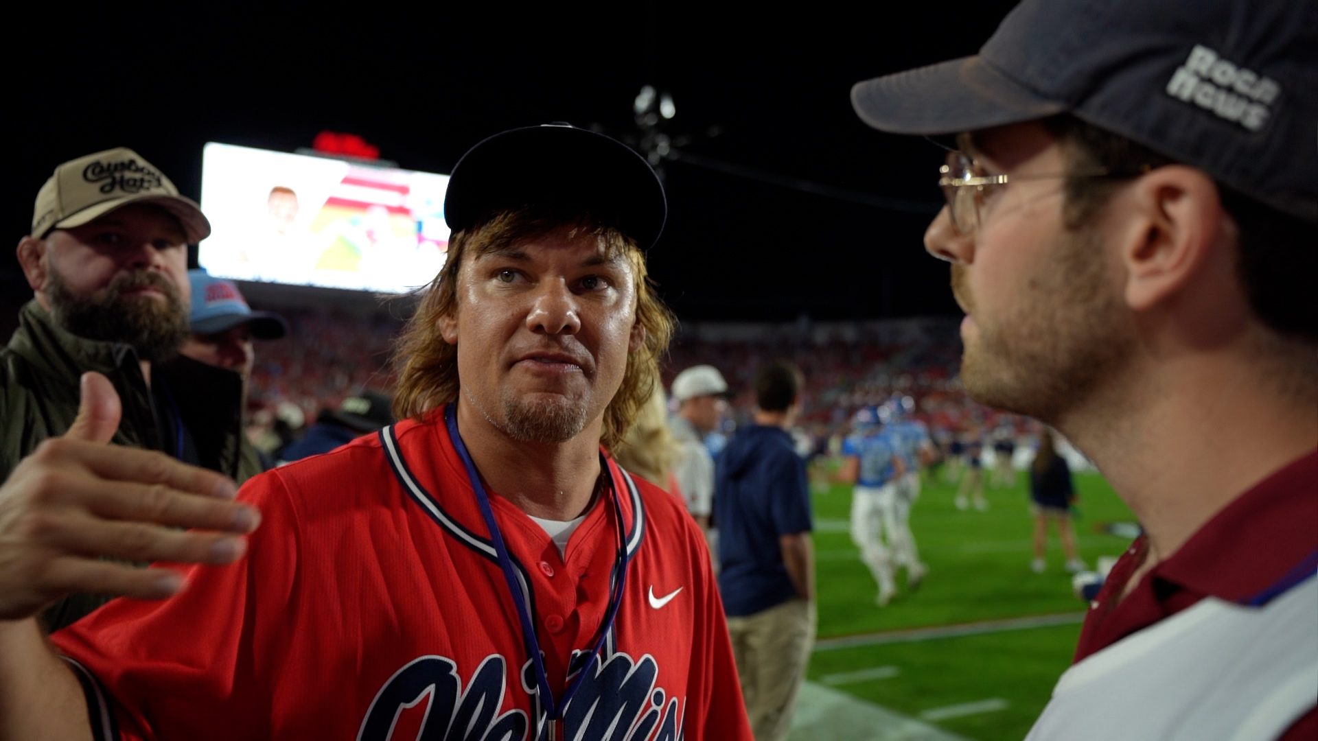 A Roca correspondent interviewing Theo Von on a college football field at night.